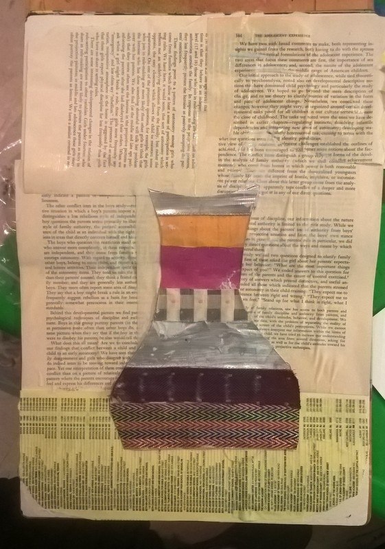 vase  covered with fabric strips on top of old book pages background