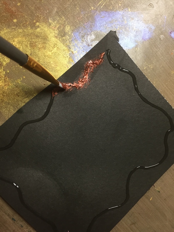 drawing design with glue on black paper and adding pigment powder