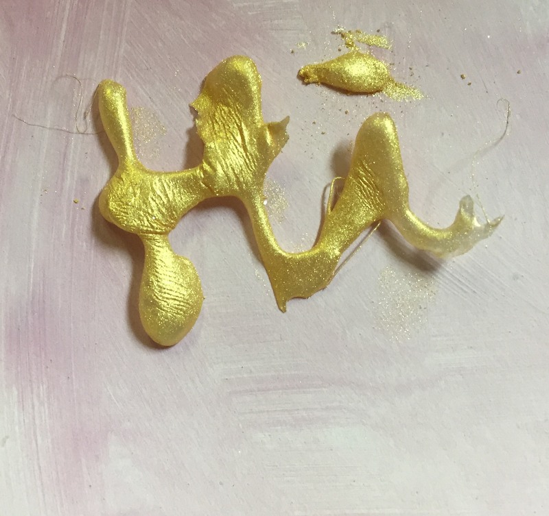 word with gold pigment powder on top