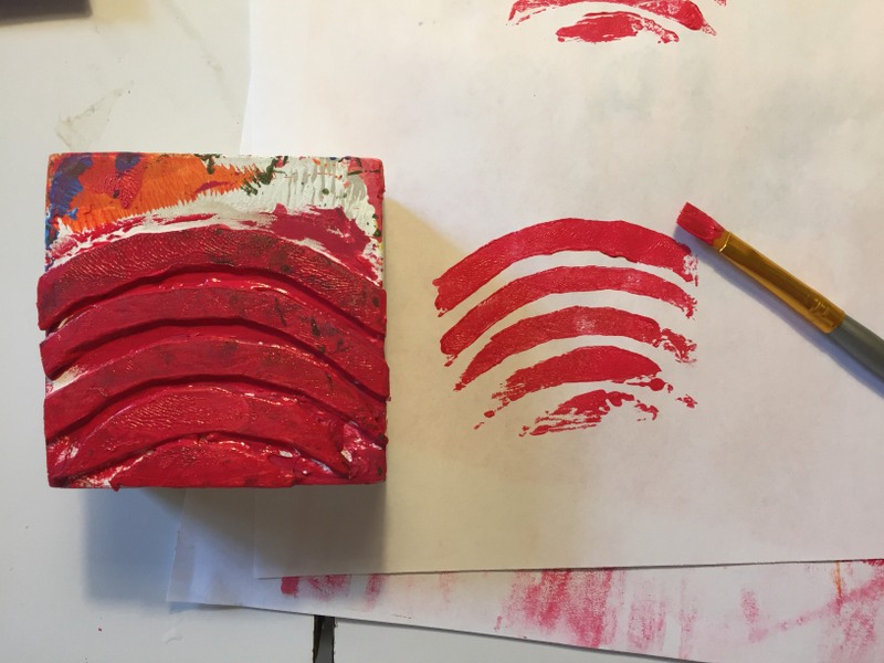 Using brush to apply paint to foam stamp